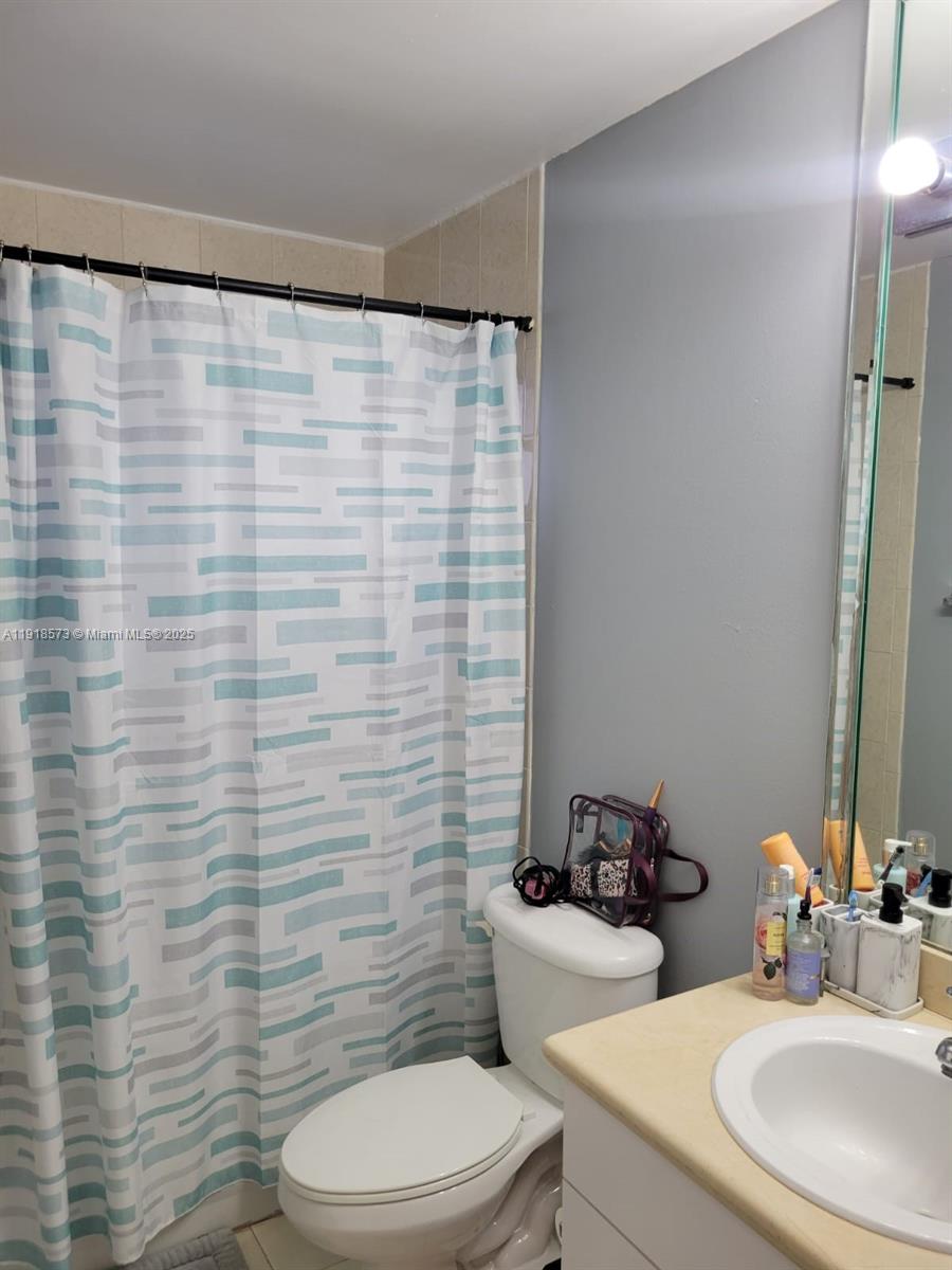 1755 West 60th Street, Unit D304 Hialeah, FL 33012 - Photo 17 of 21 a bathroom with a sink a toilet and a mirror