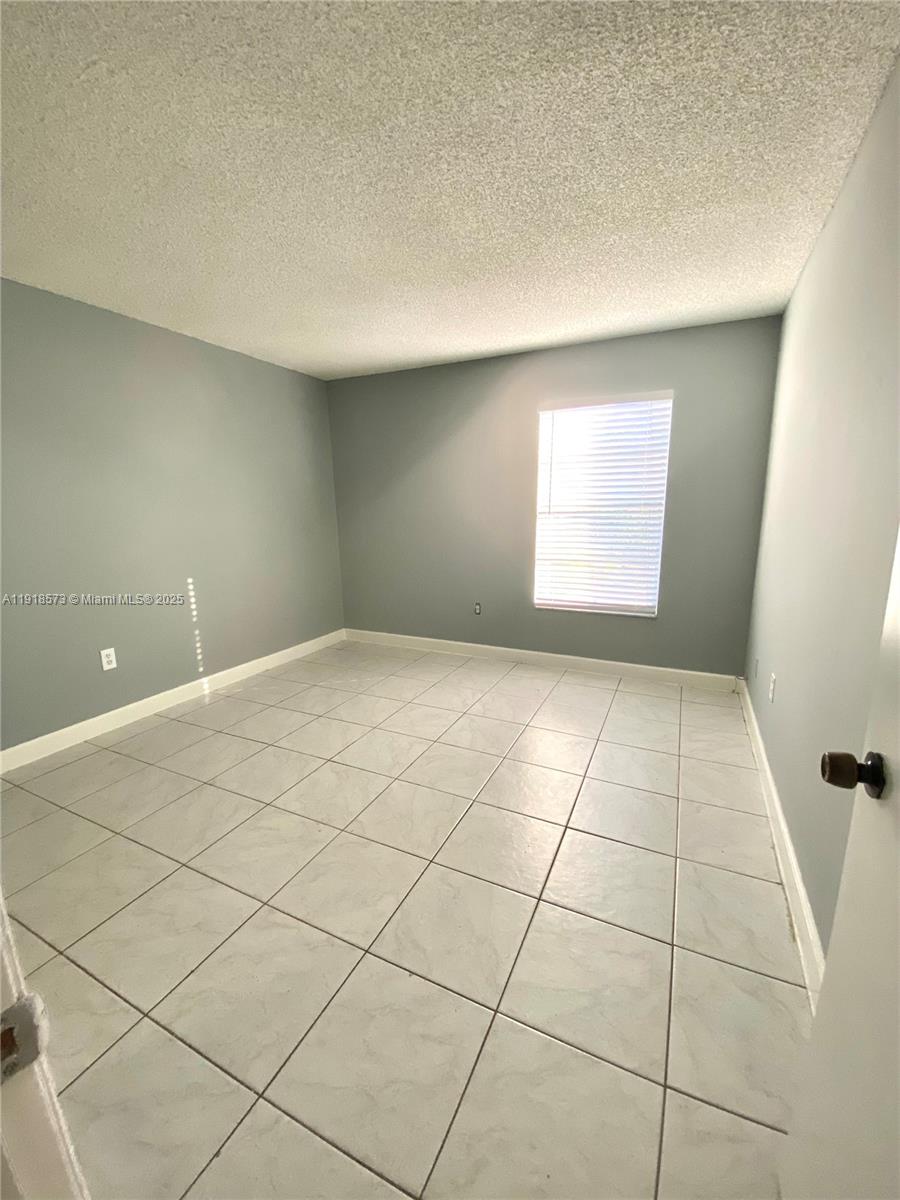 1755 West 60th Street, Unit D304 Hialeah, FL 33012 - Photo 18 of 21 a view of an empty room and window