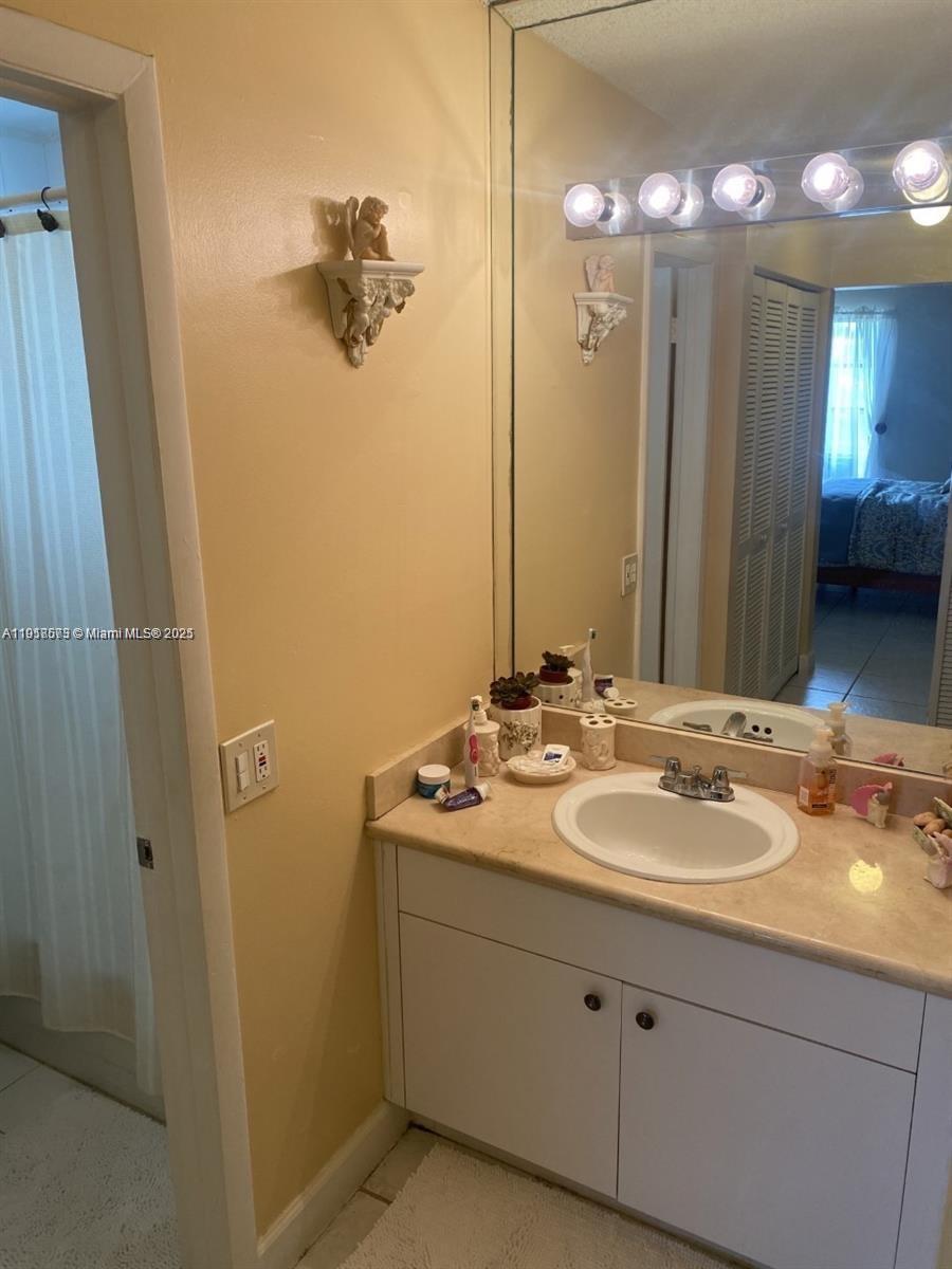 1755 West 60th Street, Unit D304 Hialeah, FL 33012 - Photo 20 of 21 a bathroom with a double vanity sink and mirror