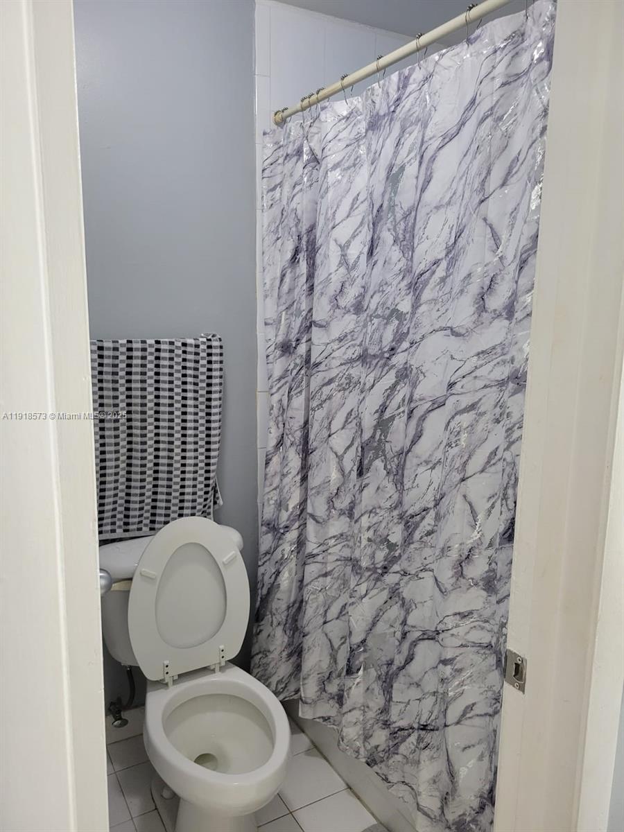 1755 West 60th Street, Unit D304 Hialeah, FL 33012 - Photo 21 of 21 a white toilet sitting next to a shower curtain