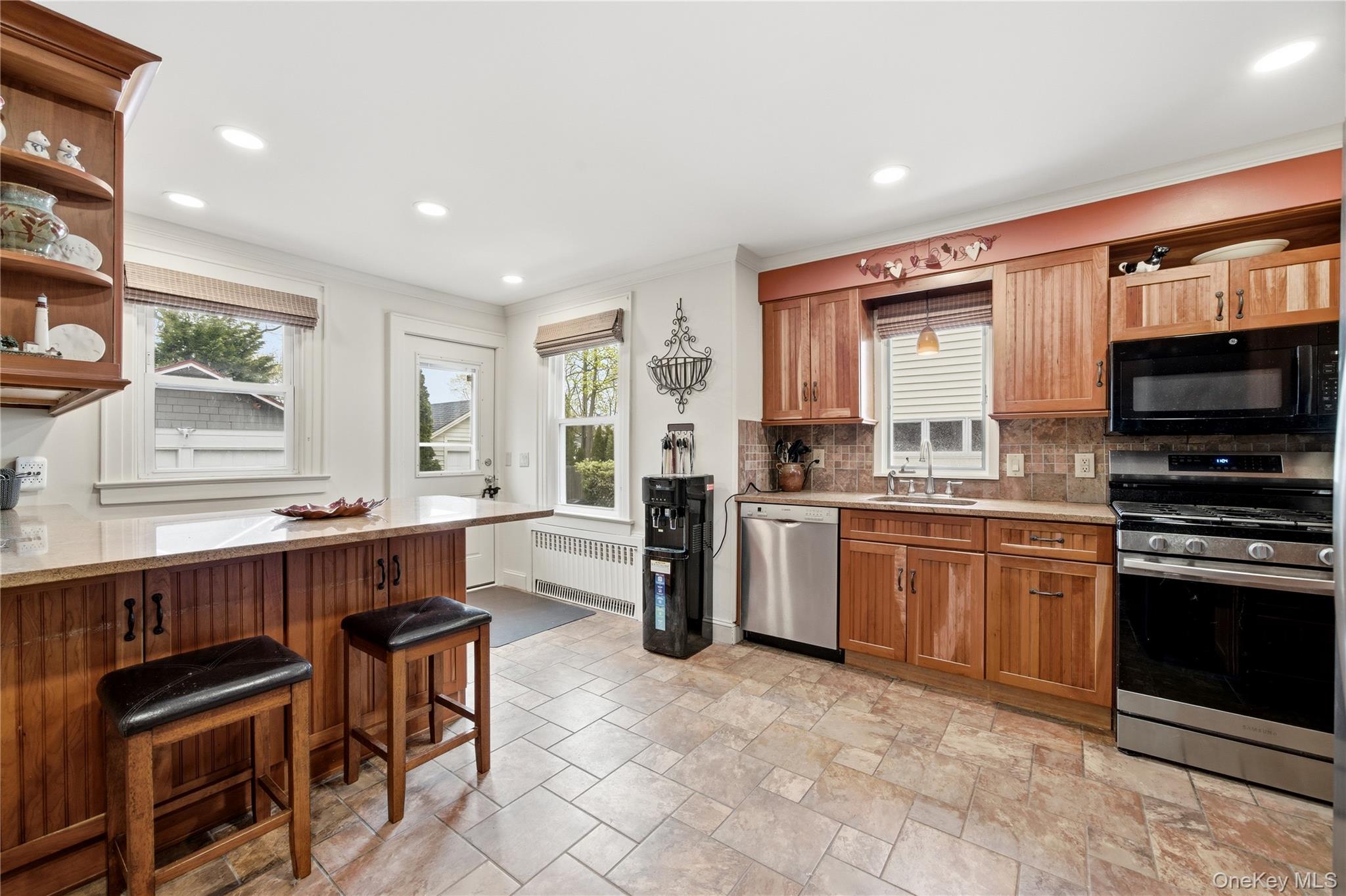 147 Church Avenue Islip, NY 11751 - Photo 20 of 40 a kitchen with stainless steel appliances granite countertop a stove top oven a sink dishwasher a dining table and chairs with wooden floor