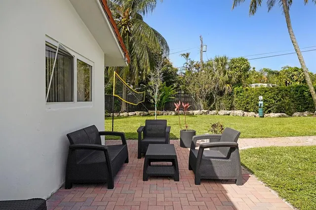 a view of a patio with couches chairs and a yard