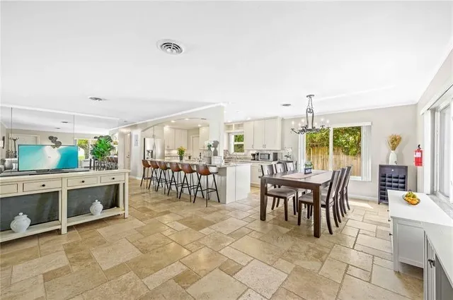a dining room with furniture and a floor to ceiling window