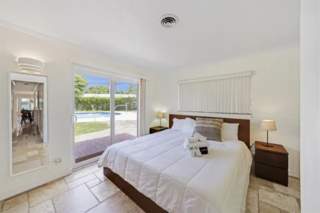 a bedroom with a bed and a large window