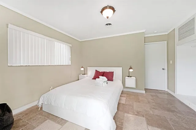 a bedroom with a large bed and a chandelier