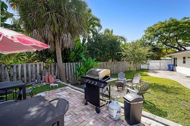 a view of a patio with table and chairs potted plants and wooden fence