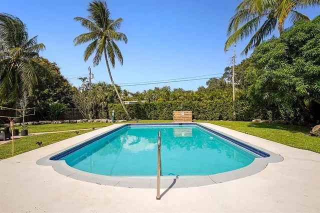a small pool with trees in the background