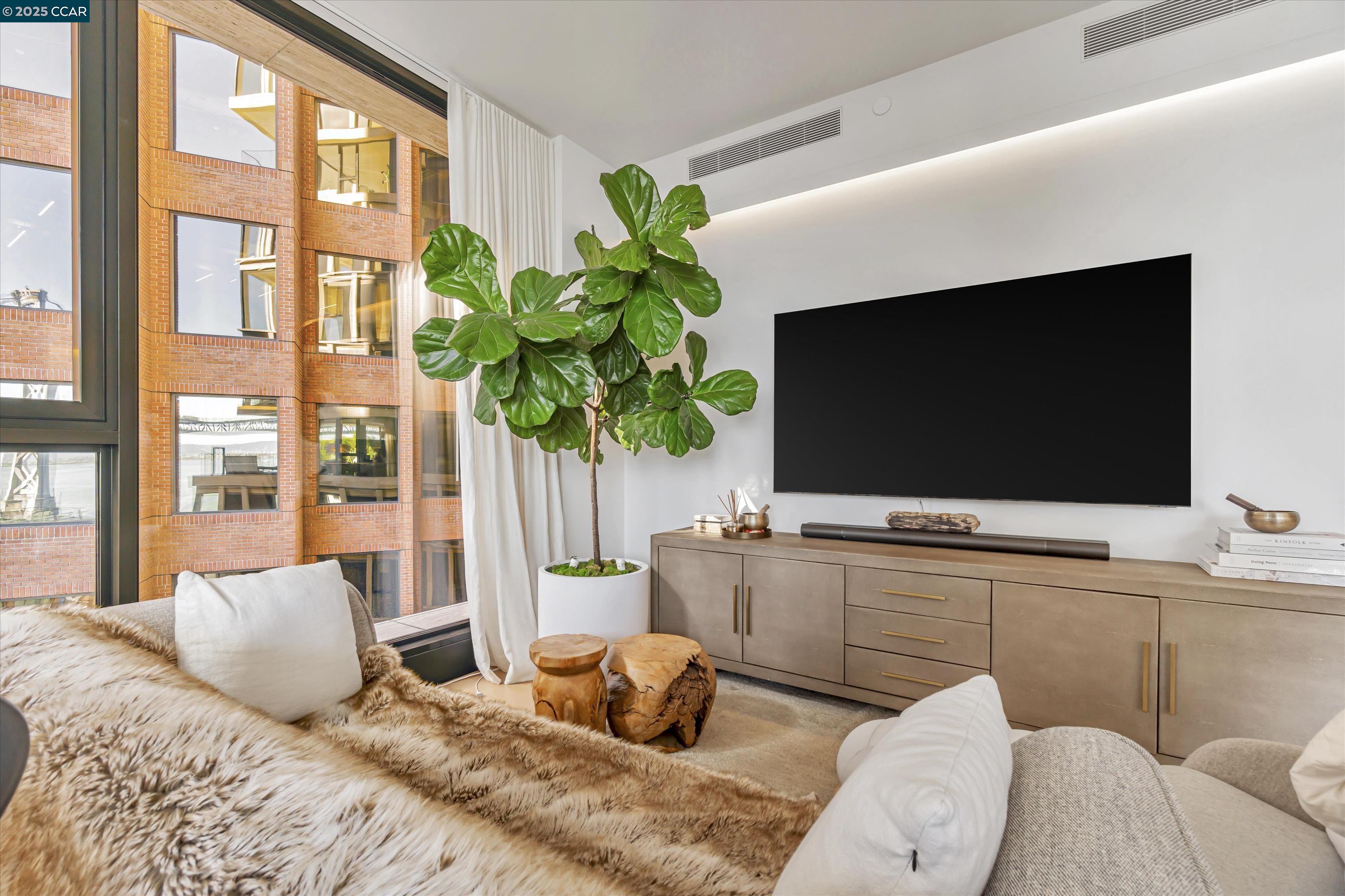 1 Steuart Street, Unit 1103 San Francisco, CA 94105 - Photo 2 of 31 a bedroom with a bed and a flat screen tv