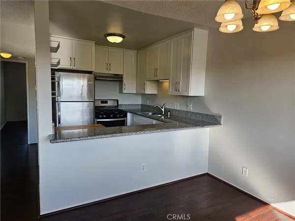 a kitchen with a refrigerator and a stove top oven
