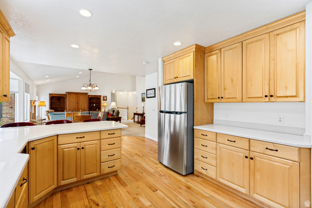 298 North Canyon Road Bountiful, UT 84010 - Photo 20 of 57 Kitchen featuring light wood cabinetry with black hardware, white countertops, stainless steel refrigerator, and wood-finish flooring