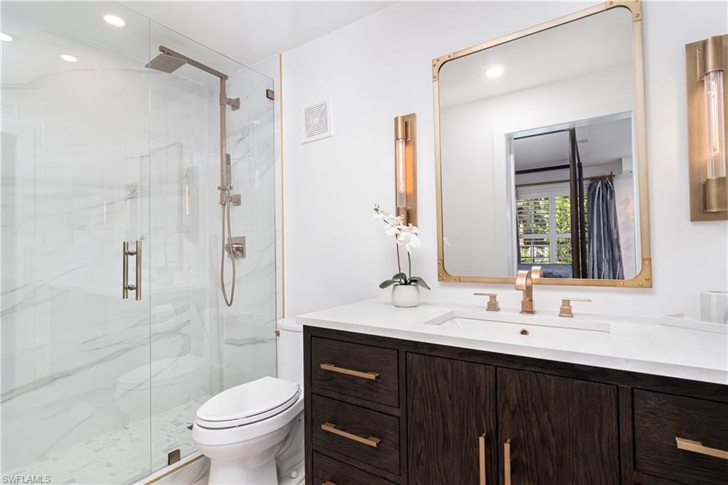 1222 Gordon Drive, Unit 4 Naples, FL 34102 - Photo 12 of 20 a bathroom with a sink vanity mirror and toilet