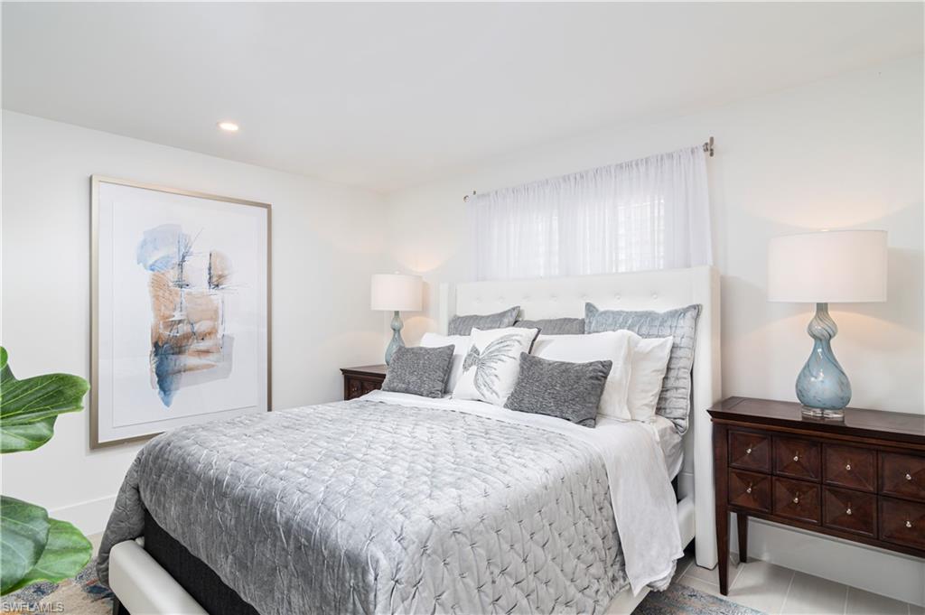 1222 Gordon Drive, Unit 4 Naples, FL 34102 - Photo 14 of 20 a bedroom with a bed and lamp with window