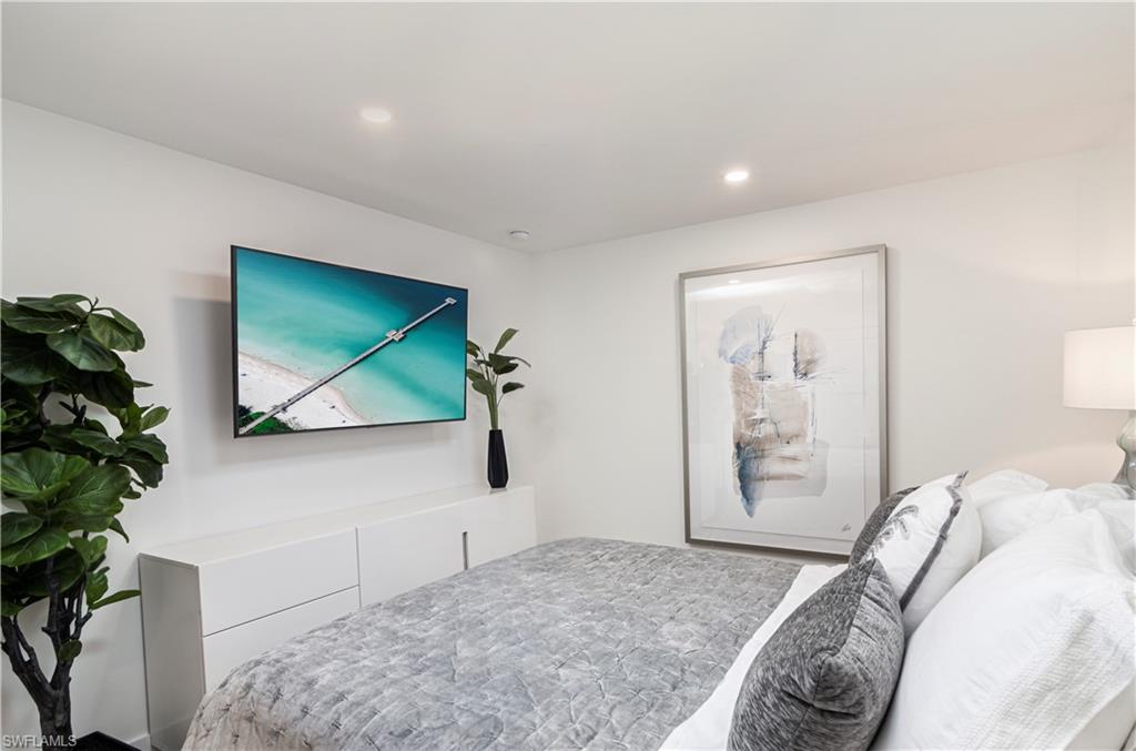 1222 Gordon Drive, Unit 4 Naples, FL 34102 - Photo 15 of 20 a bedroom with a bed and a potted plant