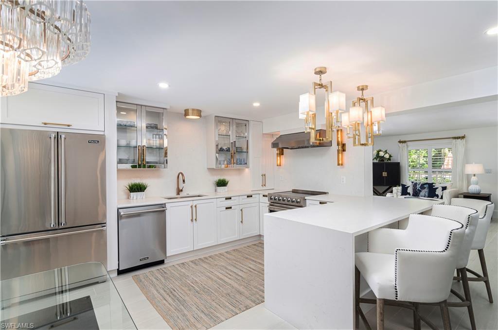 1222 Gordon Drive, Unit 4 Naples, FL 34102 - Photo 7 of 20 a kitchen with white cabinets and stainless steel appliances