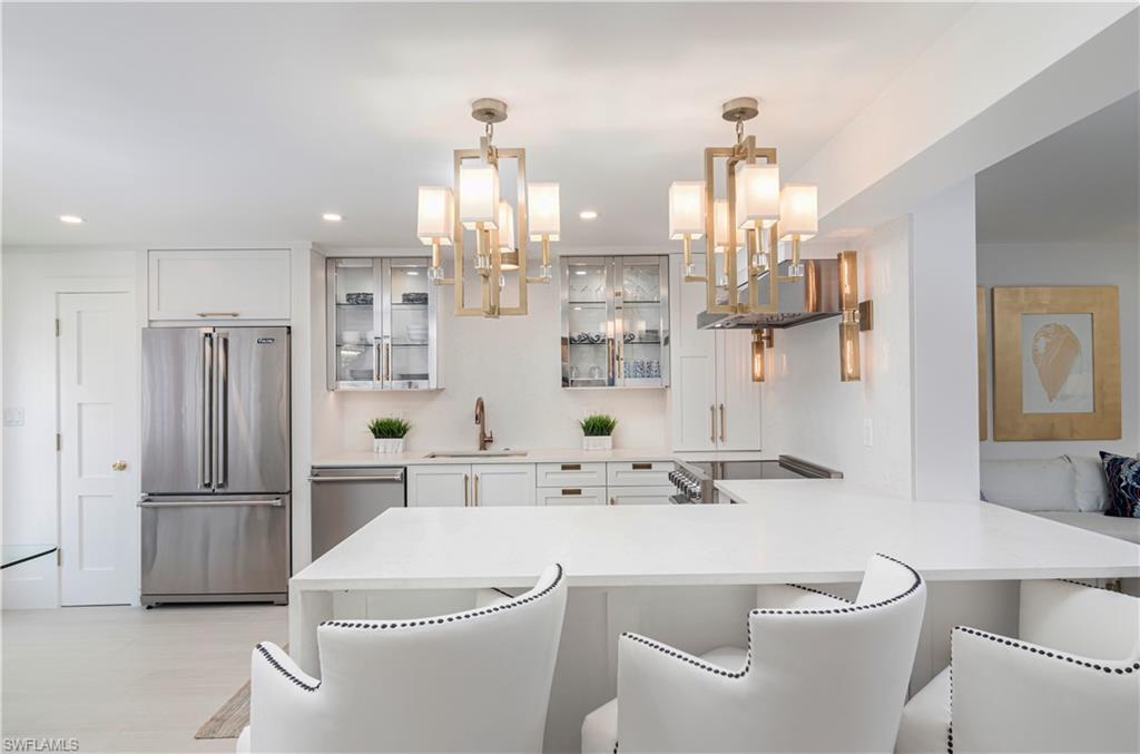 1222 Gordon Drive, Unit 4 Naples, FL 34102 - Photo 8 of 20 a bathroom with a sink a toilet and a large mirror