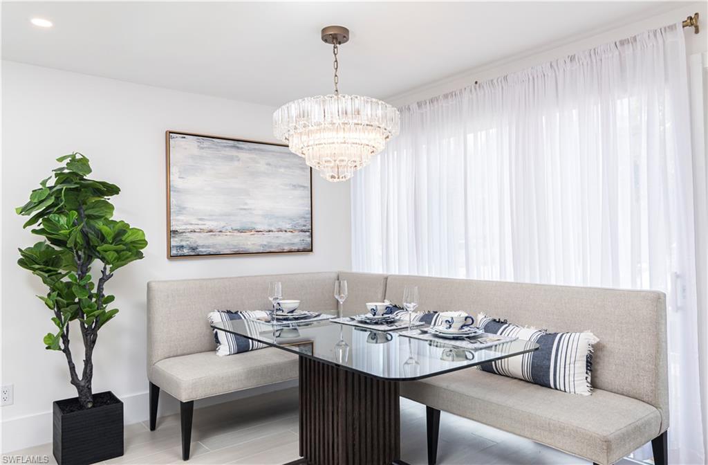 1222 Gordon Drive, Unit 4 Naples, FL 34102 - Photo 9 of 20 a living room with furniture and a chandelier