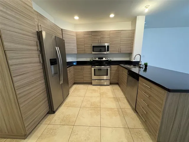 a kitchen with stainless steel appliances granite countertop a refrigerator and a stove