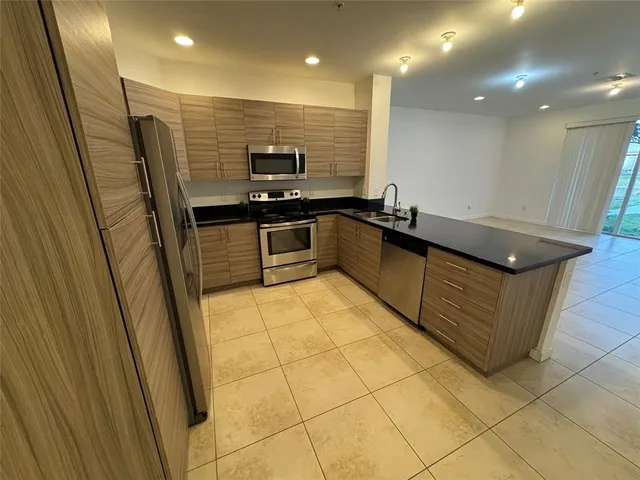 a kitchen with stainless steel appliances granite countertop a sink and a stove