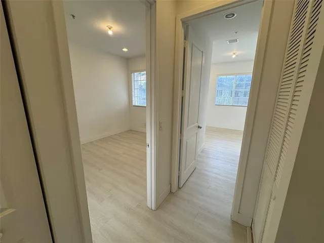 a view of a hallway with wooden floor