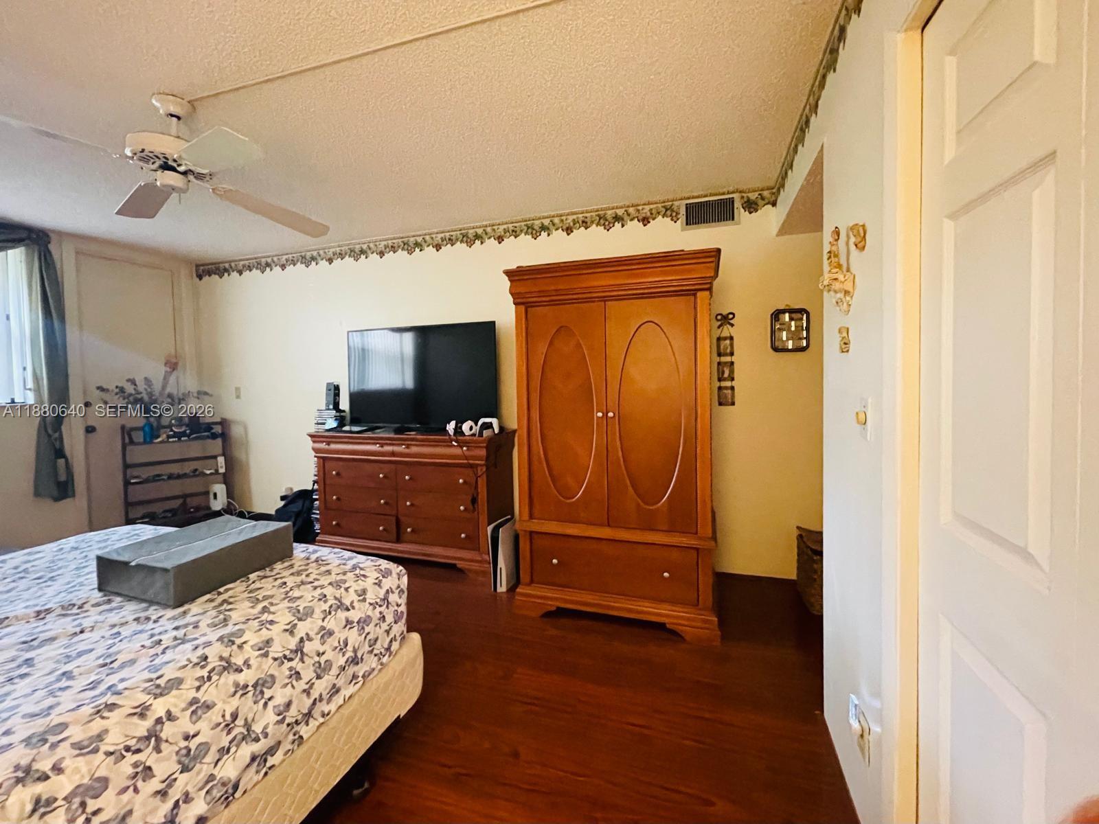 16325 Golf Club Road, Unit 102 Weston, FL 33326 - Photo 11 of 21 a bedroom with a bed and wooden floor