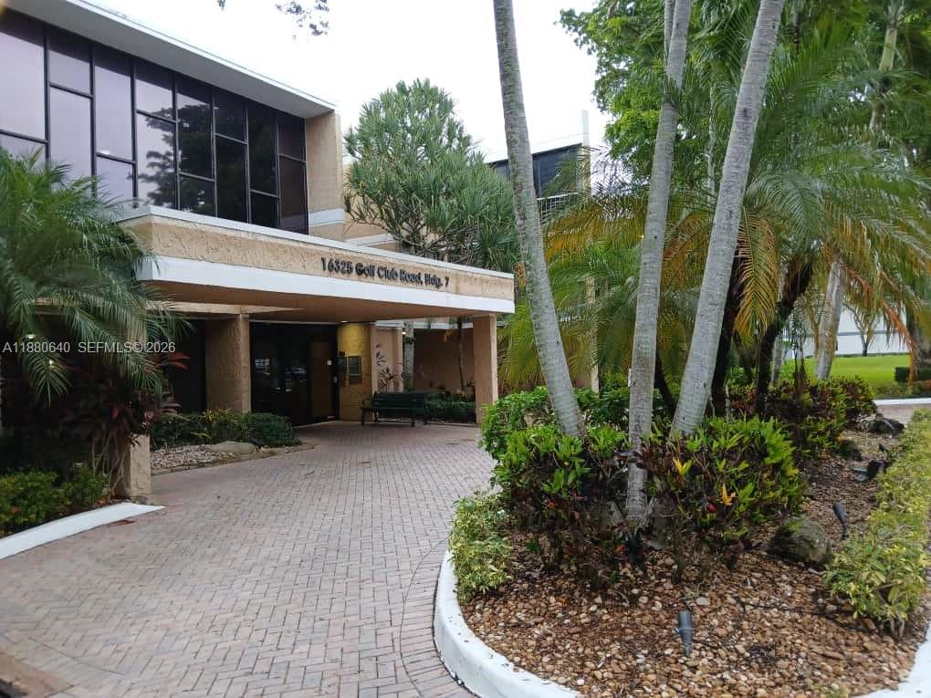 16325 Golf Club Road, Unit 102 Weston, FL 33326 - Photo 17 of 21 a view of a house with potted plants and large trees