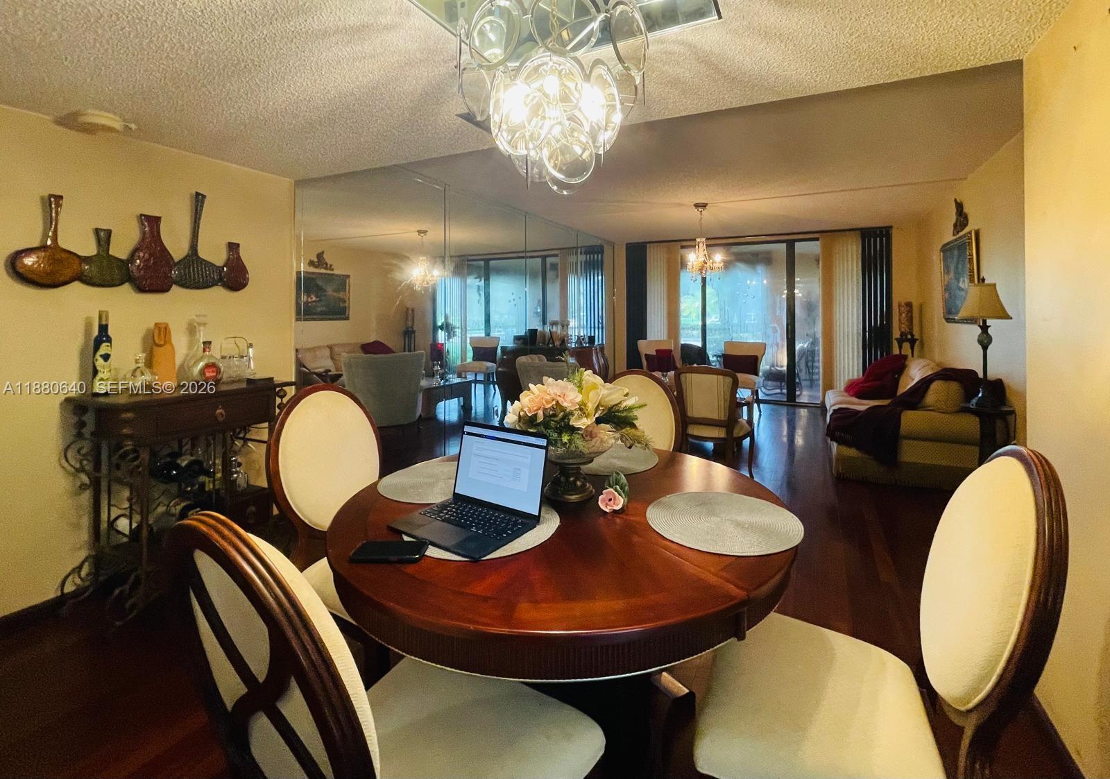 16325 Golf Club Road, Unit 102 Weston, FL 33326 - Photo 7 of 21 a dining room with furniture a chandelier and wooden floor