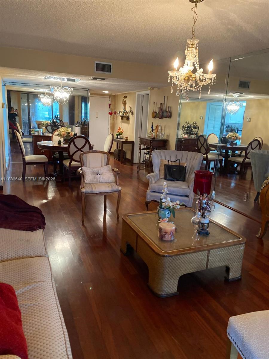 16325 Golf Club Road, Unit 102 Weston, FL 33326 - Photo 8 of 21 a living room with furniture and a chandelier