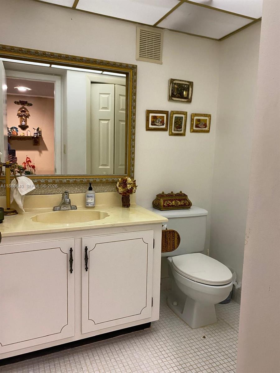 16325 Golf Club Road, Unit 102 Weston, FL 33326 - Photo 9 of 21 a bathroom with a granite countertop toilet sink and mirror