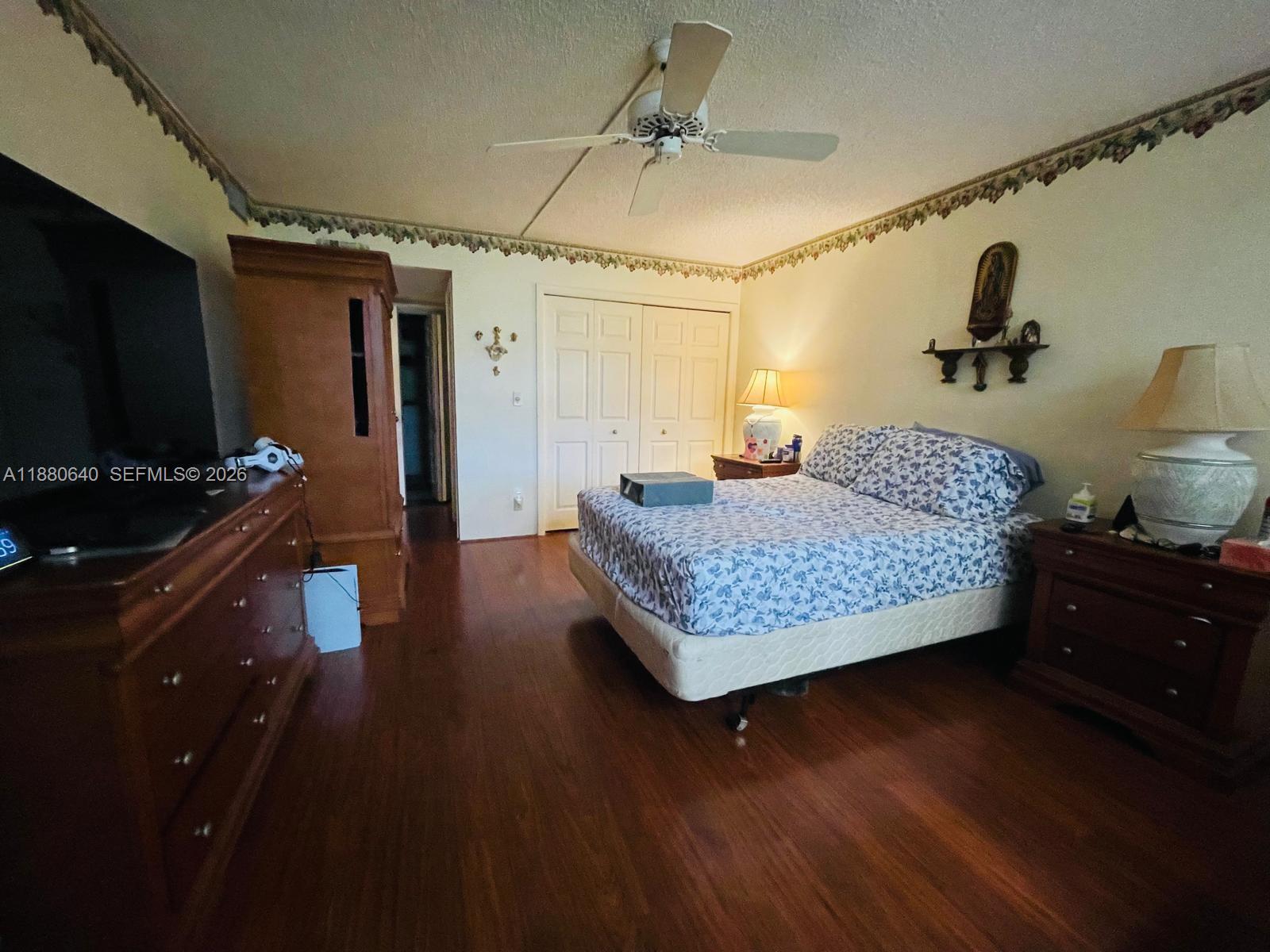 16325 Golf Club Road, Unit 102 Weston, FL 33326 - Photo 10 of 21 a bedroom with a bed and wooden floor