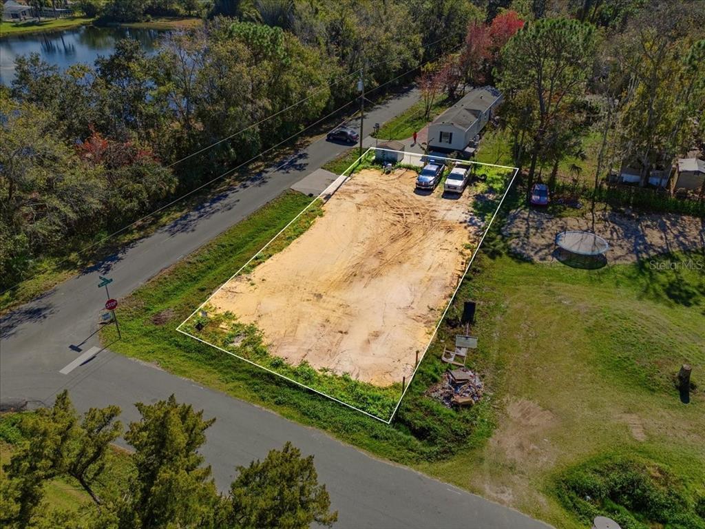 an aerial view of a house with a yard and lake view