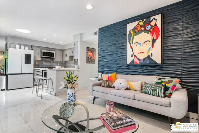 a living room with furniture potted plant and kitchen view