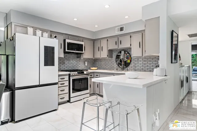 a kitchen with white cabinets stainless steel appliances and sink