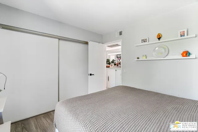 a bed sitting in a bedroom next to a window