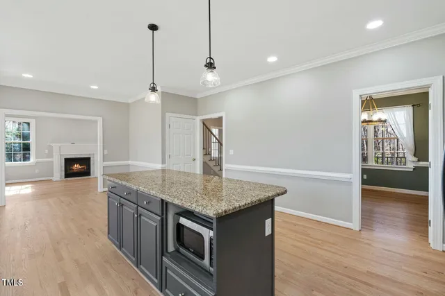 a kitchen with stainless steel appliances granite countertop a sink a stove and a wooden floors