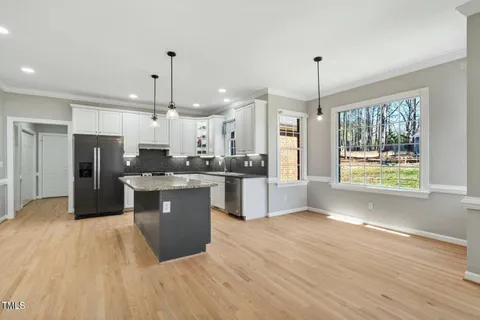 a large kitchen with kitchen island a sink stainless steel appliances and window