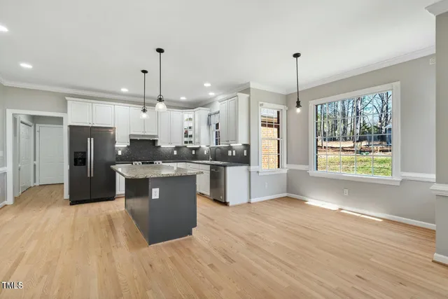 a large kitchen with kitchen island a sink stainless steel appliances and window