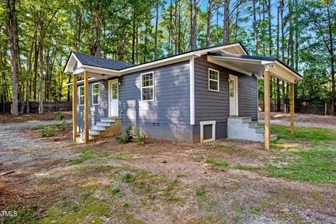 a backyard of a house with table and chairs