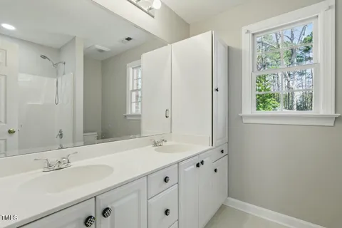 a bathroom with double vanity sink and a mirror