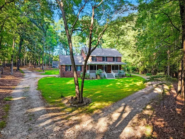 a front view of a house with a garden and plants