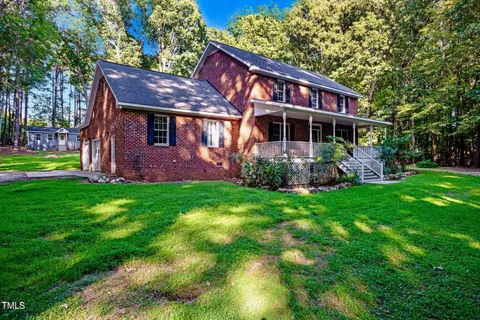 a front view of a house with a garden and plants