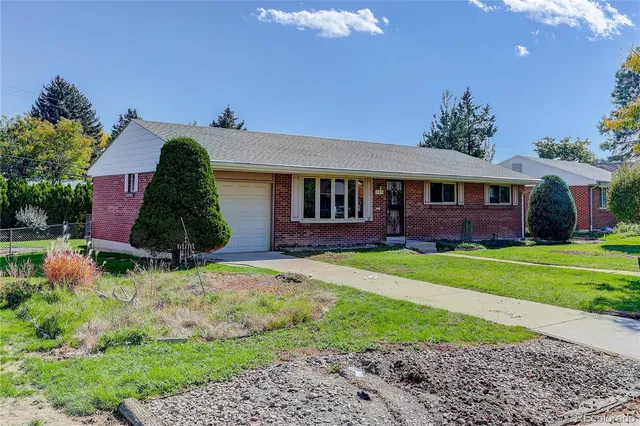 a front view of a house with a garden and plants