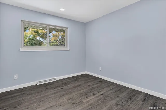 a view of an empty room with wooden floor