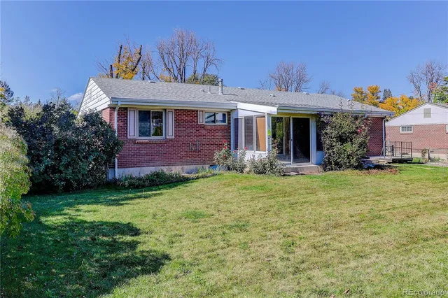 a view of a backyard with couches plants and large tree