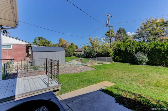 a view of a green yard with a house in the background