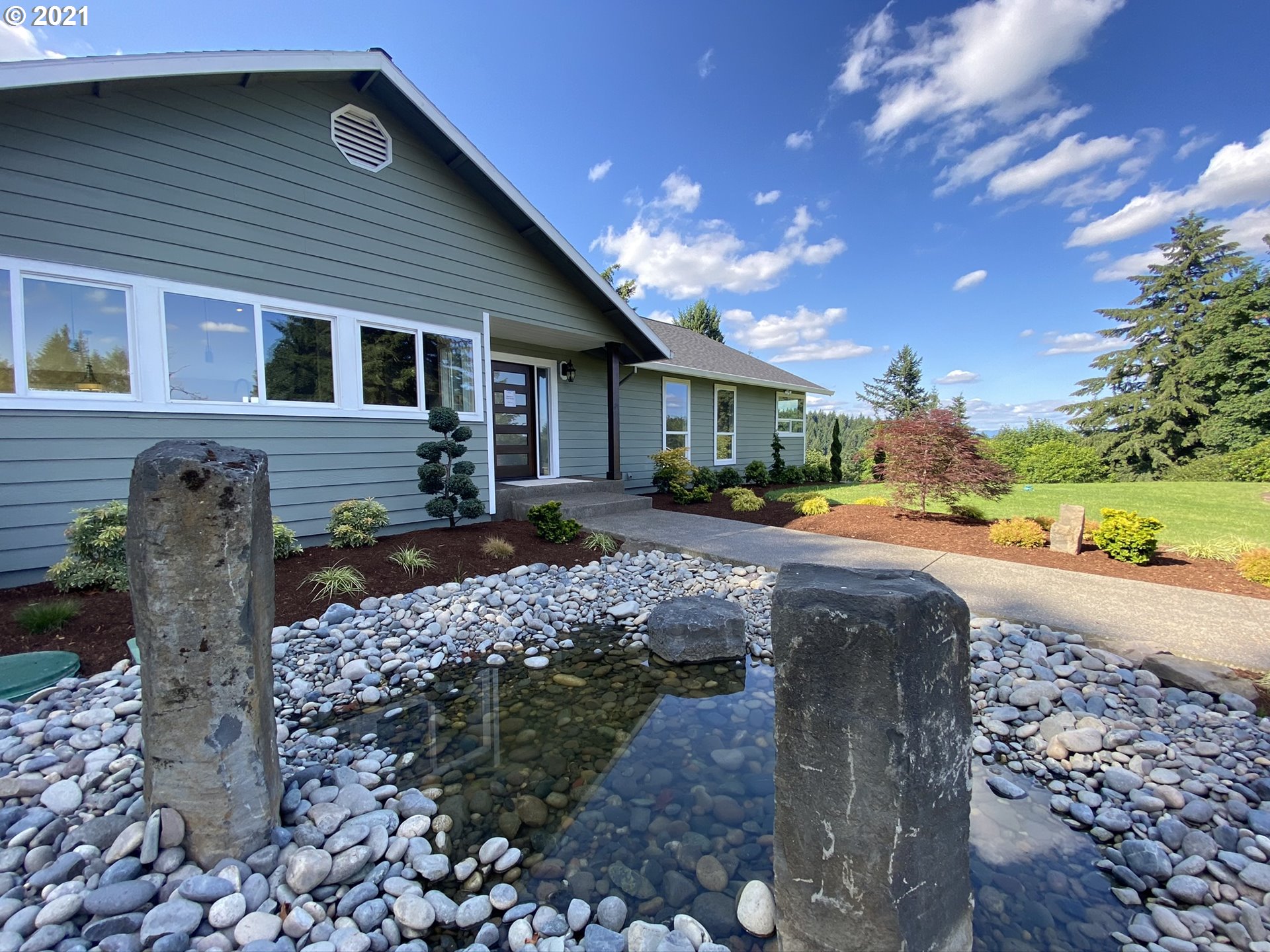 a front view of a house with a yard and outdoor seating
