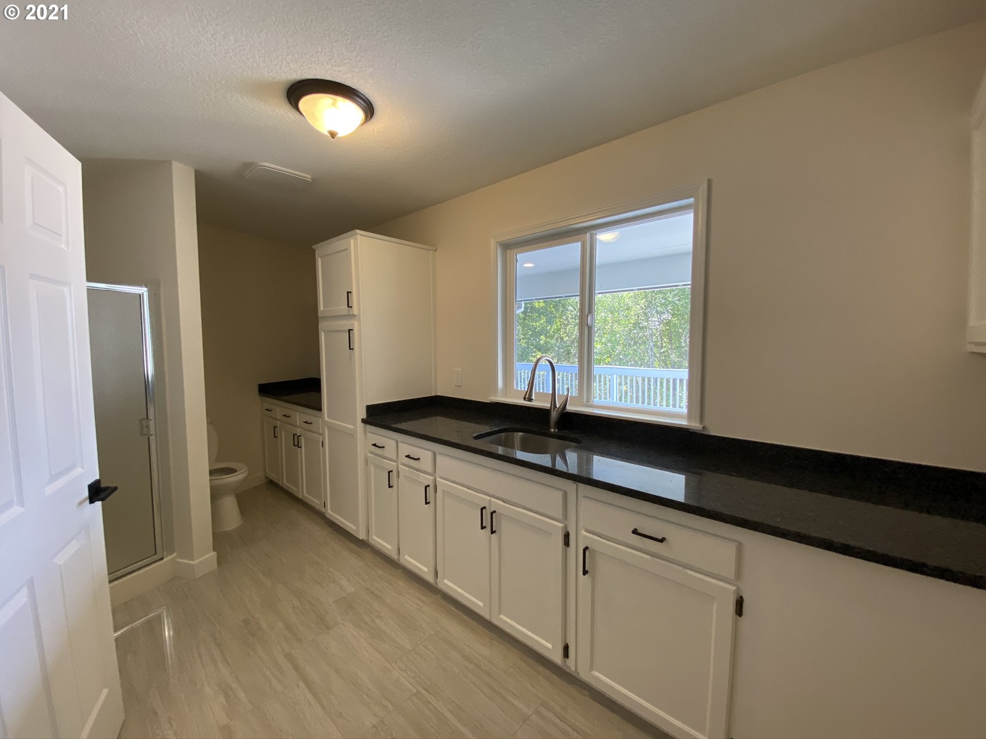 8900 Southeast Alder Ridge Road Damascus, OR 97089 - Photo 21 of 32 a kitchen with granite countertop white cabinets and sink