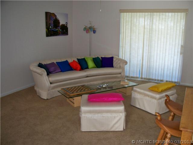 1980 Southwest Palm City Road, Unit 50C Stuart, FL 34994 - Photo 3 of 23 Living Room. Living room with newer carpet and sliding glass doors to screened porch with storage closet