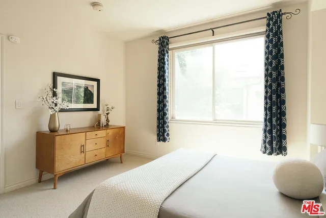 a bedroom with a bed and painting on the wall