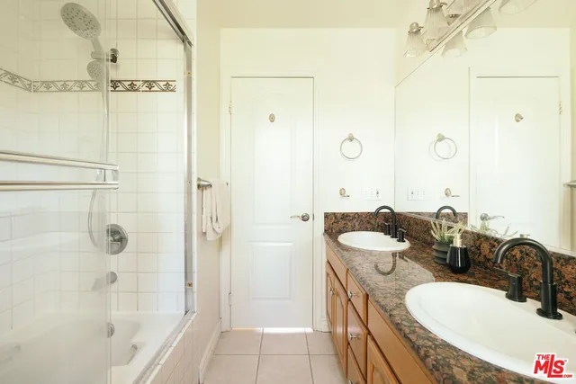 a view of a hallway with wooden floor and a bathroom