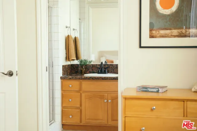 a bathroom with a granite countertop sink and a mirror